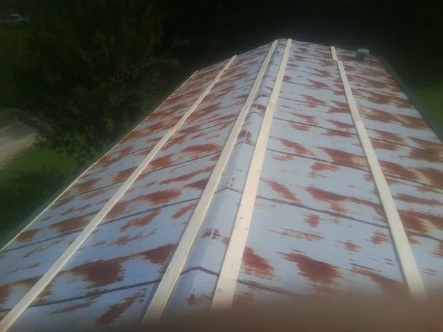 Rusted metal roof panels with new wood purlins before replacement — Storm Damage Roof Repair in Follansbee by Roofing Brothers