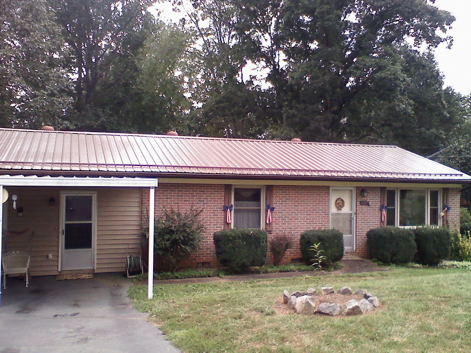 Bronze metal roof and carport on a brick ranch home — Roof Repair work by our crew in Follansbee